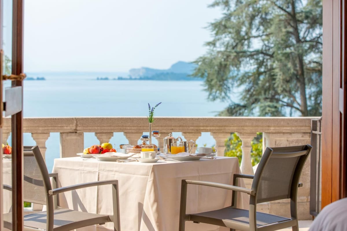 A table set for breakfast with a view of a body of water and trees.