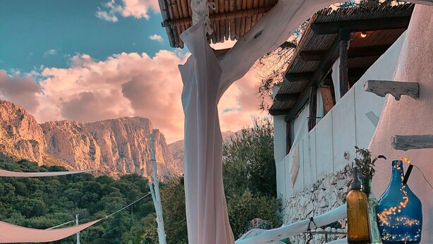Una terraza con una mesa preparada para una comida, con vistas a un paisaje montañoso.