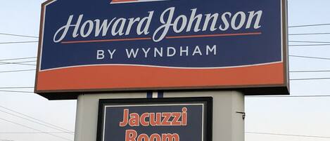 A sign for Howard Johnson by Wyndham with a sub-sign indicating a Jacuzzi room is available.