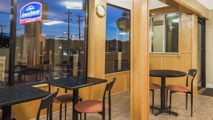 A Howard Johnson Express Inn with a view of the sky through the window, wooden interior, and tables with chairs.