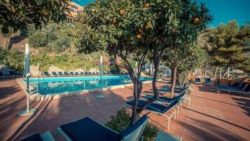 Utomhuspool, parasoller och solstolar