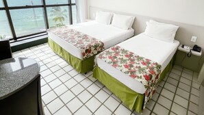 A hotel room with two beds, a desk, and a view of the ocean. - Hotel Golden Park Recife By Nacional Inn (Recife)
