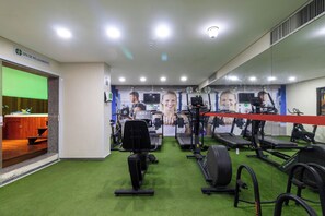 A gym with exercise equipment, a green artificial turf floor, and a wall with fitness-related posters. - Hotel Golden Park Recife Boa Viagem By Nacional Inn (Recife)