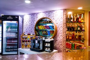 Un quiosco de bebidas con una máquina de café y un dispensador refrigerado.