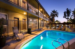 Una piscina al aire libre, tumbonas