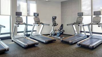 A fitness room with treadmills, a stationary bike, and a rowing machine.