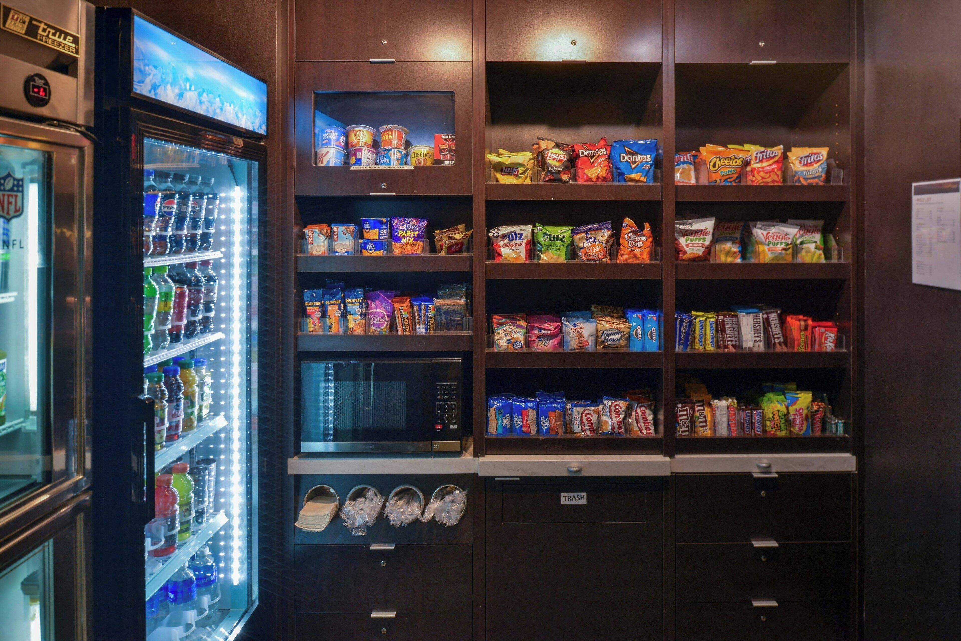 A vending machine area with snacks, drinks, and a microwave.