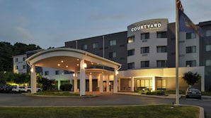 Un hotel Courtyard by Marriott amb entrada coberta, diversos pisos i un penya-art.