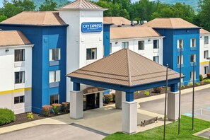 A hotel with a blue and white exterior, a covered entrance, and a sign indicating it is a City Express by Marriott.