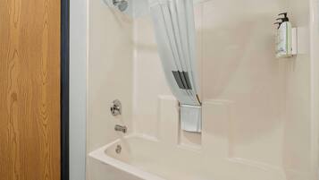 Een moderne badkamer met een bad, een douche en een toilet.