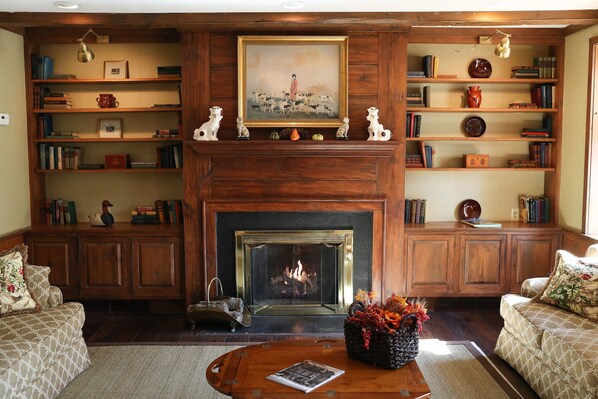 A cozy living room with a fireplace, bookshelves, and two sofas. - Golden Plough Inn At Peddlers Village (New Hope)