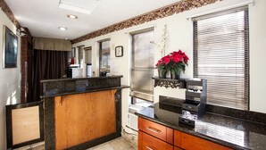 A kitchen with a wooden counter, a sink, and a window with blinds. - Super 8 by Wyndham Vancouver East (Vancouver)