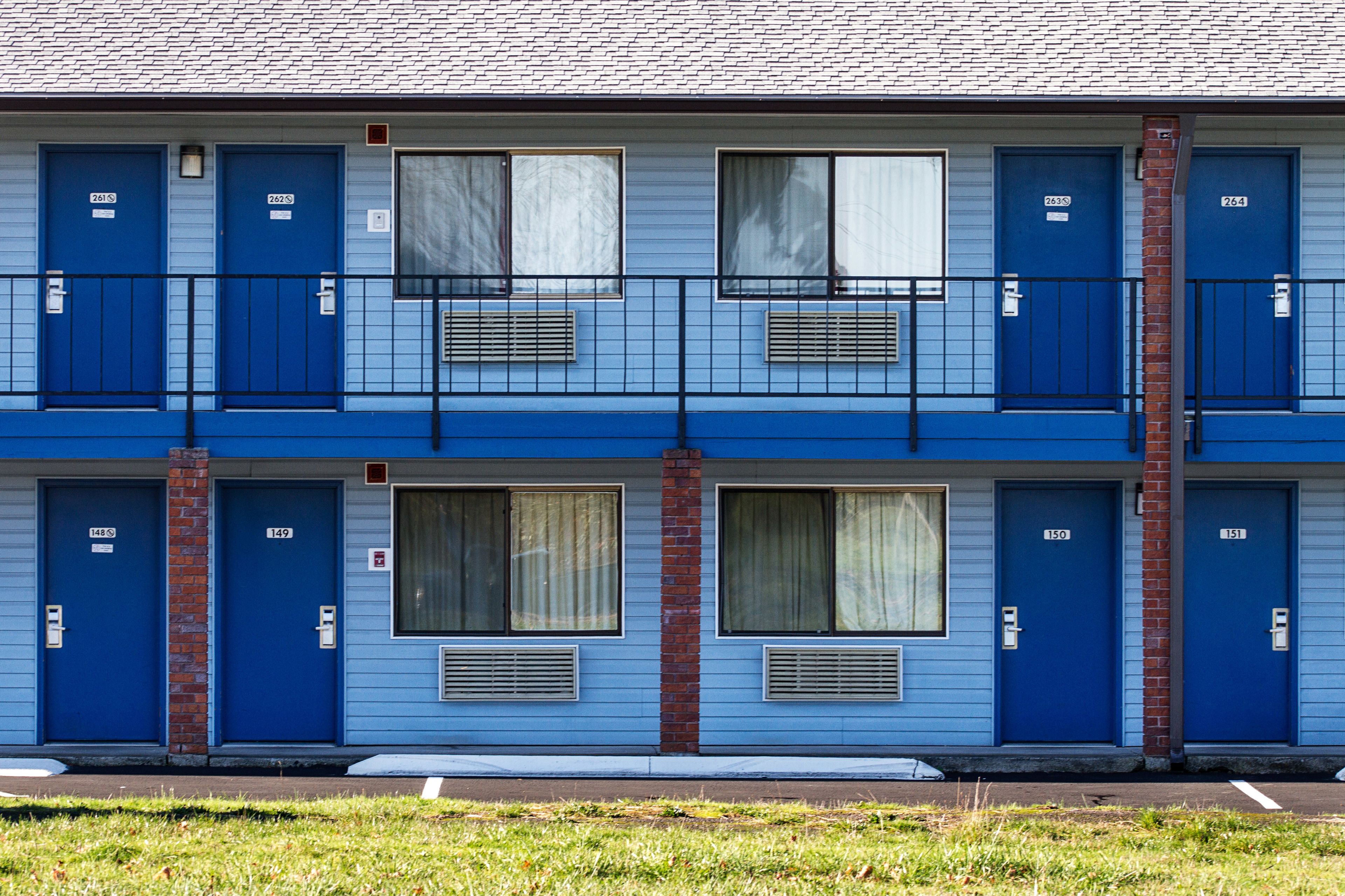 A two-story motel with blue doors numbered 148 to 151.