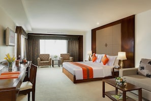 A hotel room with a large bed, a sofa, a desk, and two armchairs. - Mövenpick Suriwongse Hotel Chiang Mai (Chiang Mai)