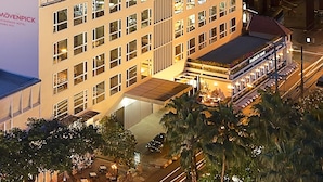 Un hôtel à plusieurs étages au design moderne, doté d’une terrasse sur le toit et d’un restaurant situé au rez-de-chaussée.
