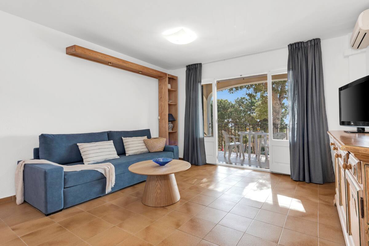 Uma sala de estar moderna com um sofá azul, uma mesa de centro de madeira e uma televisão em um móvel de madeira.