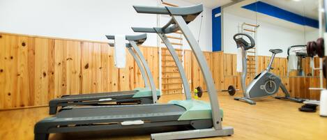 A gym with treadmills, a stationary bike, and a weight bench.