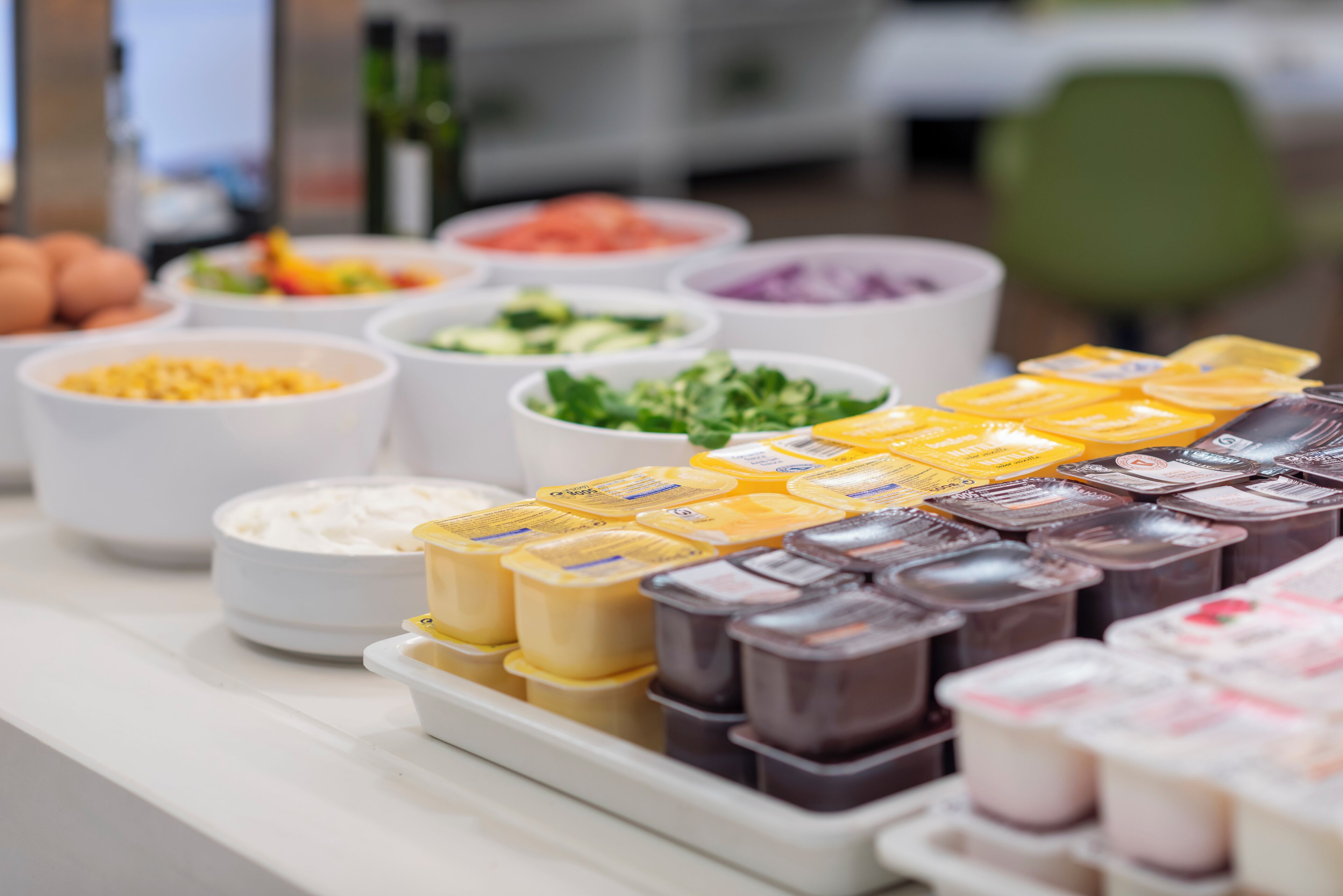 A buffet with various food items including eggs, salads, and different types of spreads.