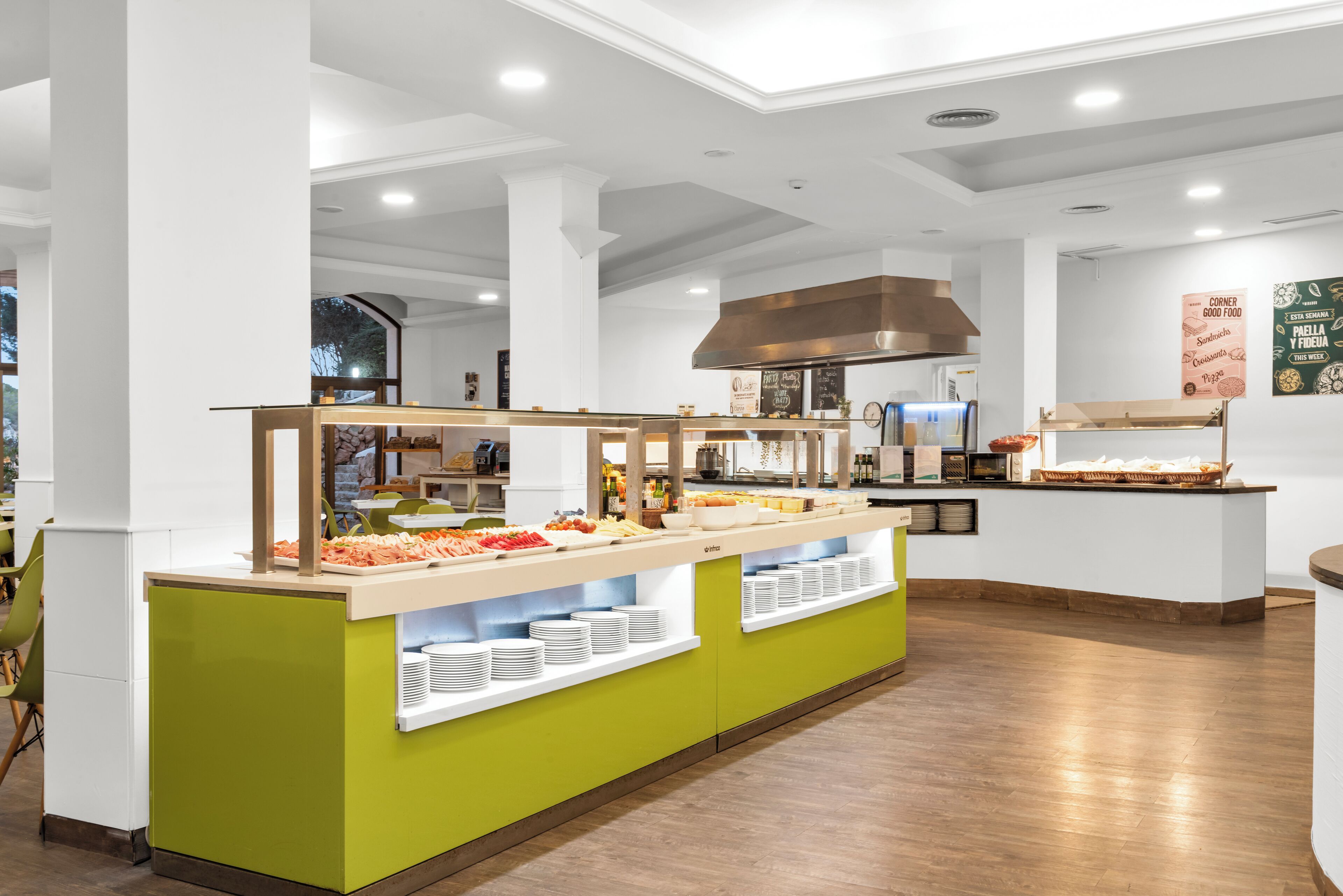 A buffet area with multiple food stations, a central serving counter, and a large industrial range hood.