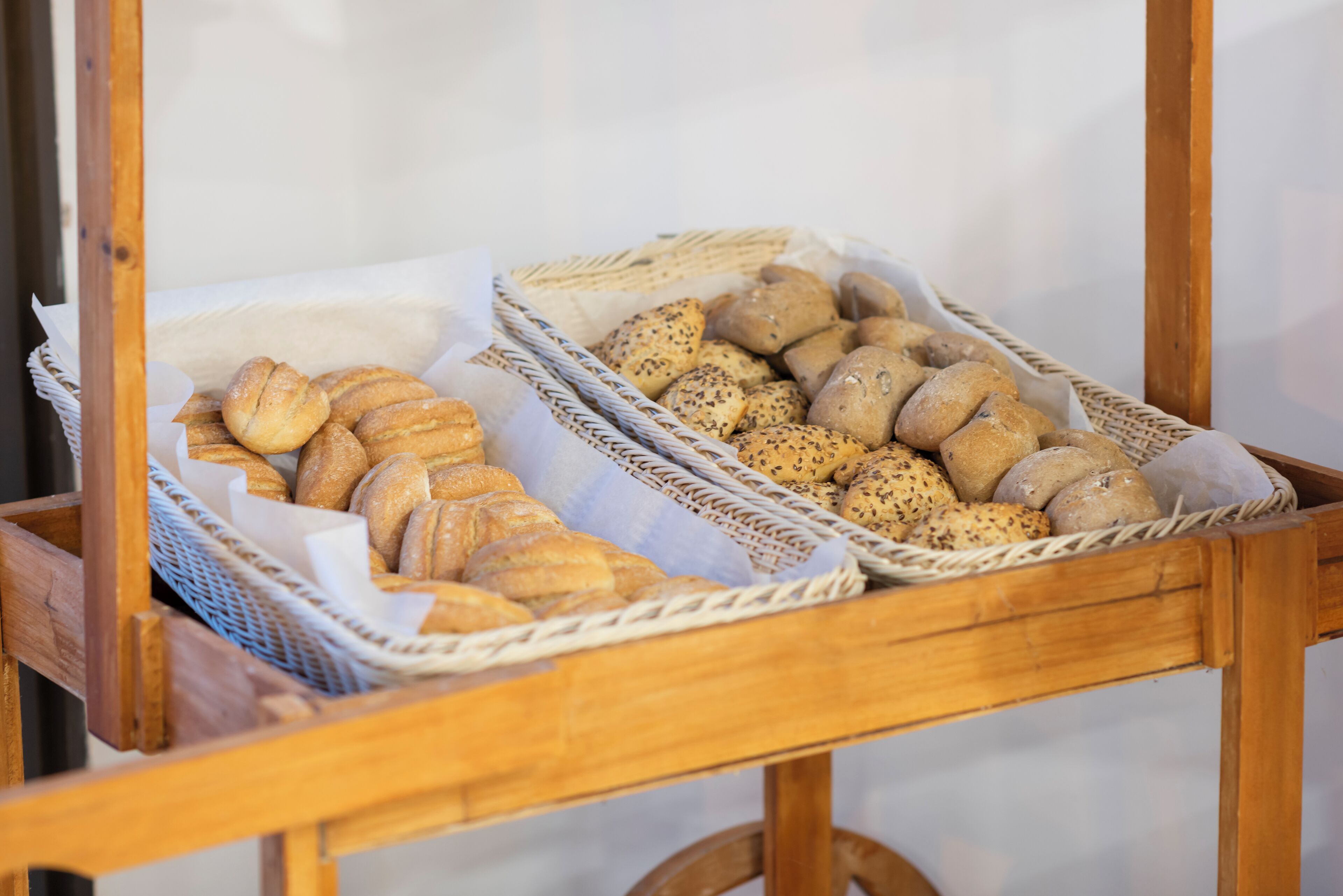 A wooden cart with baskets containing various types of bread.