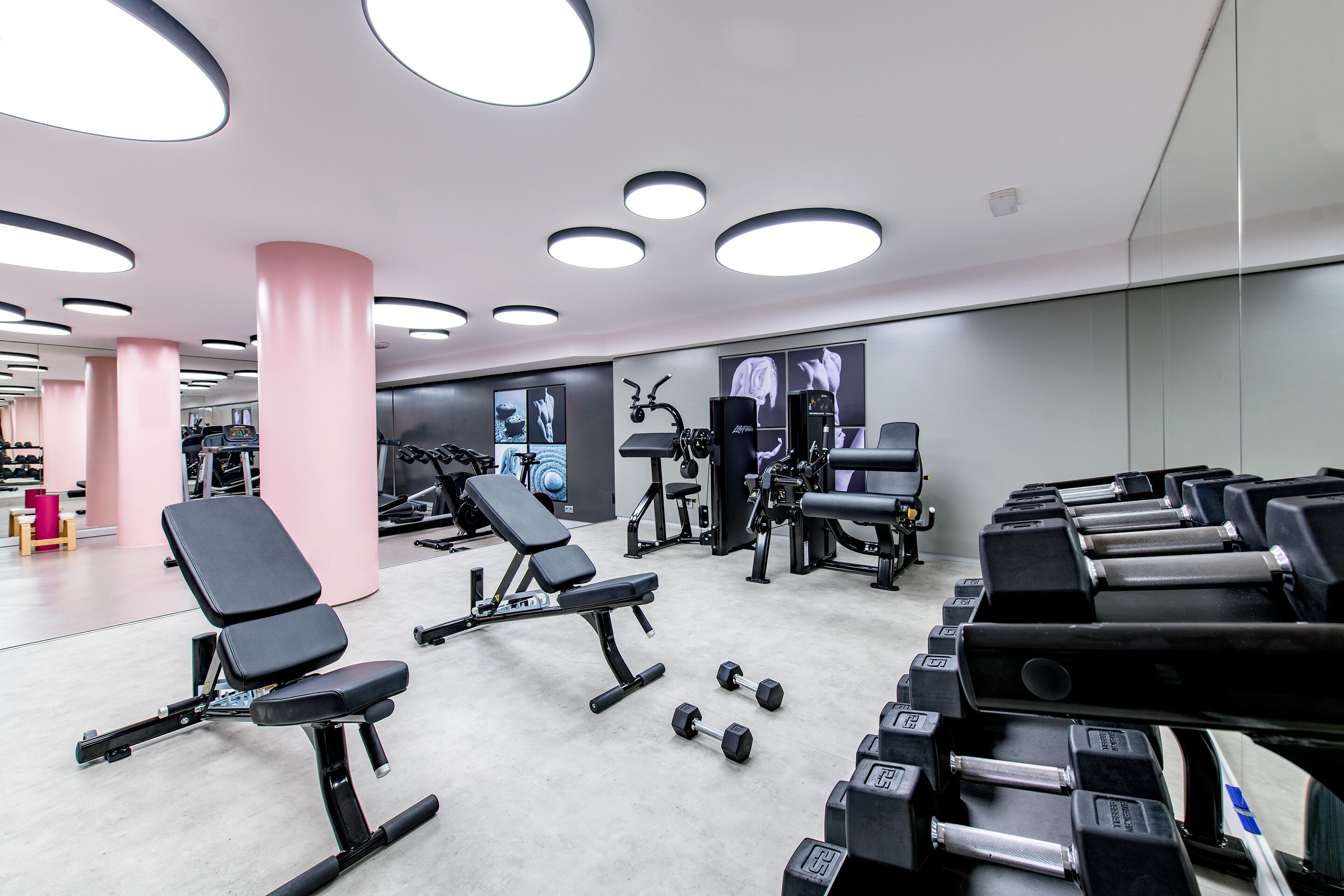 Una palestra con attrezzature per esercizi, panche e manubri.