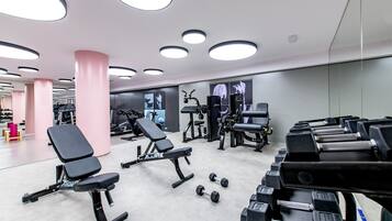 Una palestra con attrezzature per esercizi, panche e manubri.