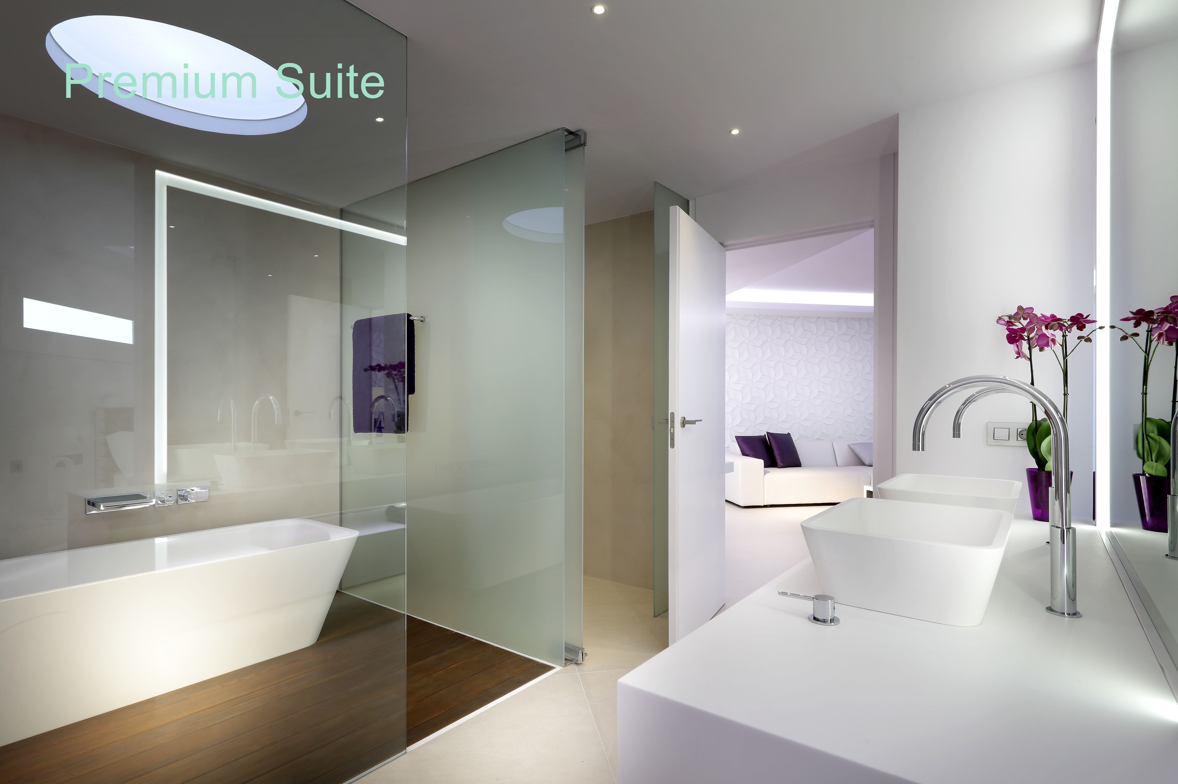 A modern bathroom with a large bathtub, two sinks, and a glass shower enclosure.