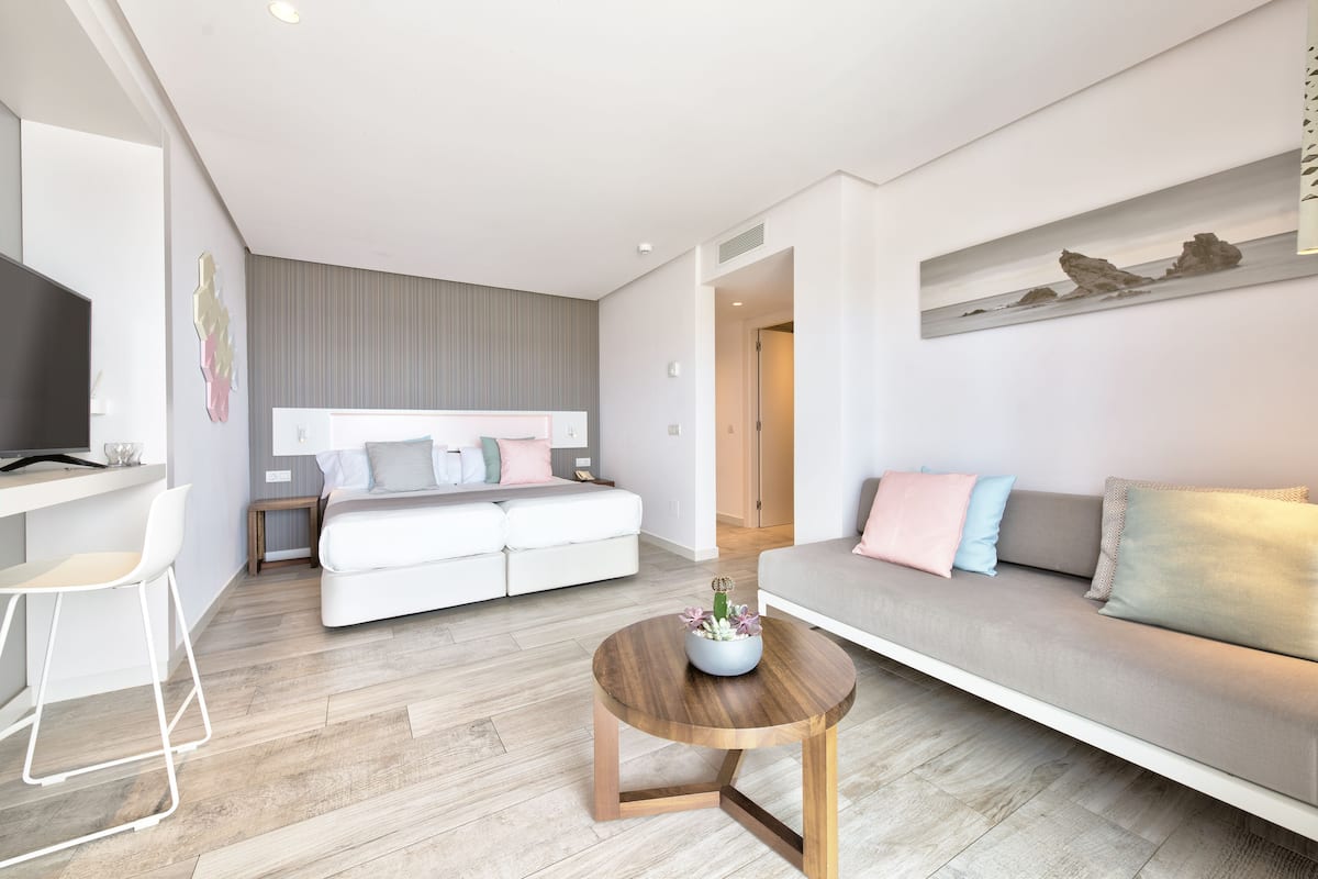 A modern living room with a sofa, a coffee table, and a TV.