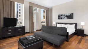 A modern hotel room with a large bed, a sofa, a TV, and a desk. - Hotel 57 (New York)