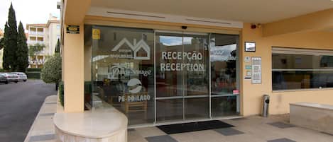 A hotel reception with a glass door, a sign for 'Reception', and a 'Park' sign.