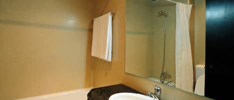 A modern bathroom with a bathtub, a sink, and a large mirror.