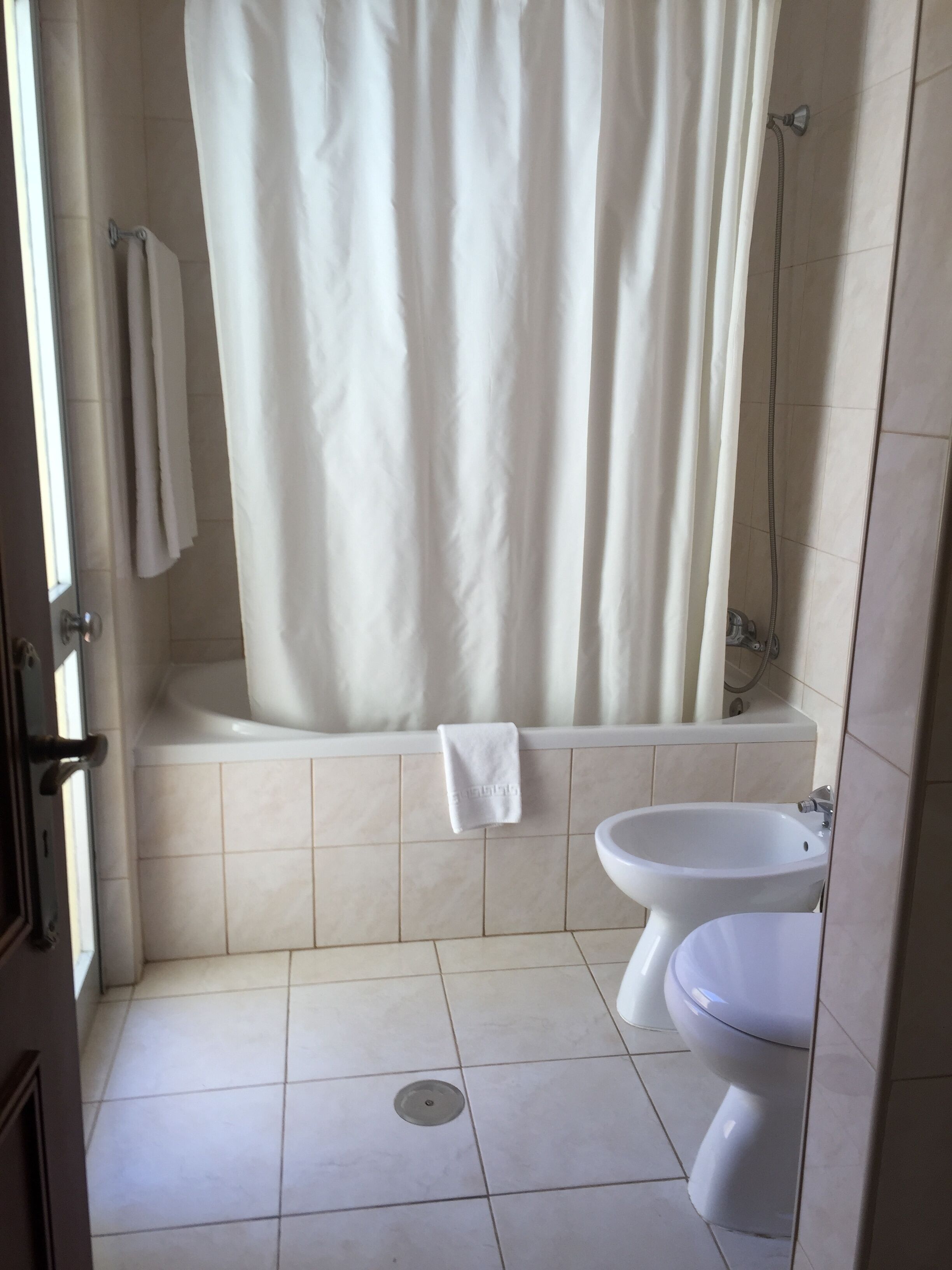 Ein Badezimmer mit Badewanne, Dusche und Toilette.