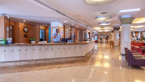 A hotel reception area with a marble counter, a clock, and a reception desk. - Invisa Hotel La Cala (Santa Eulalia del Rio)