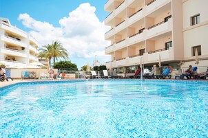 Una piscina al aire libre, sombrillas, tumbonas
