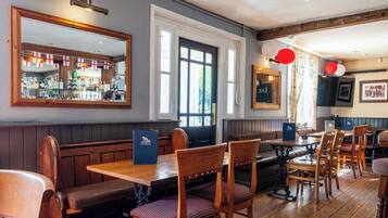 En restaurang med träbeklädda bås, en bardisk med flaskor och en stor spegel.