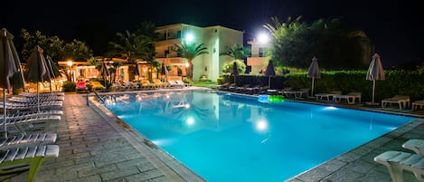 Alberca al aire libre y camastros