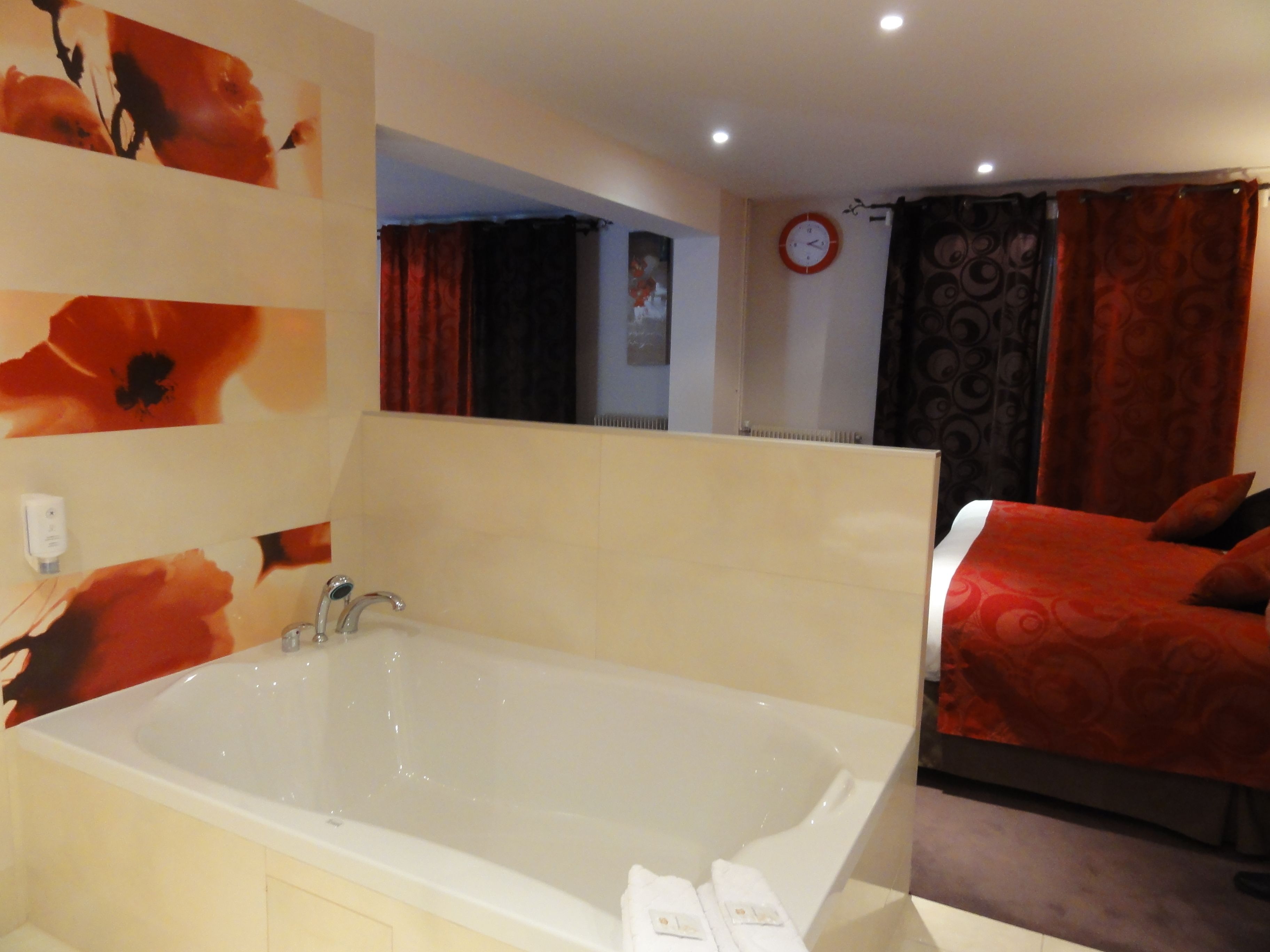 A modern bathroom with a large bathtub, a mirror, and a clock on the wall.