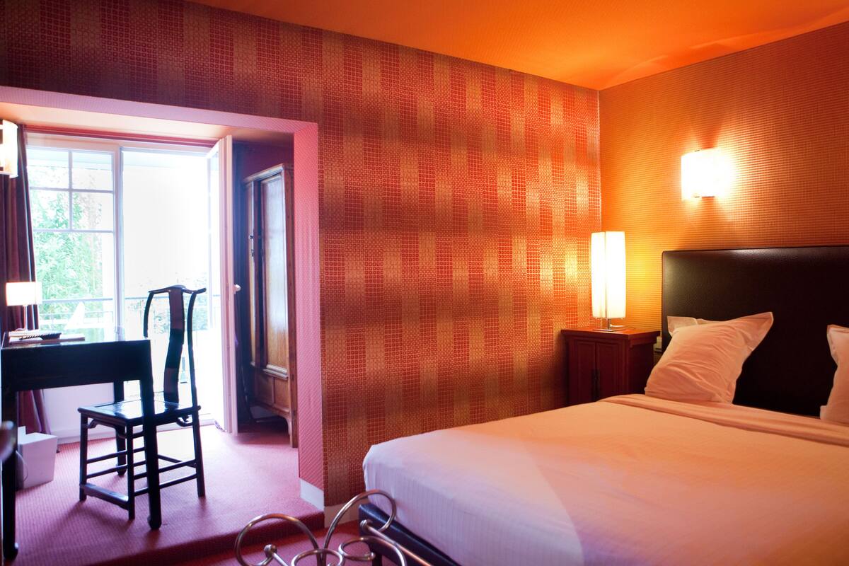 Une chambre d’hôtel avec un lit, un bureau et une chaise.