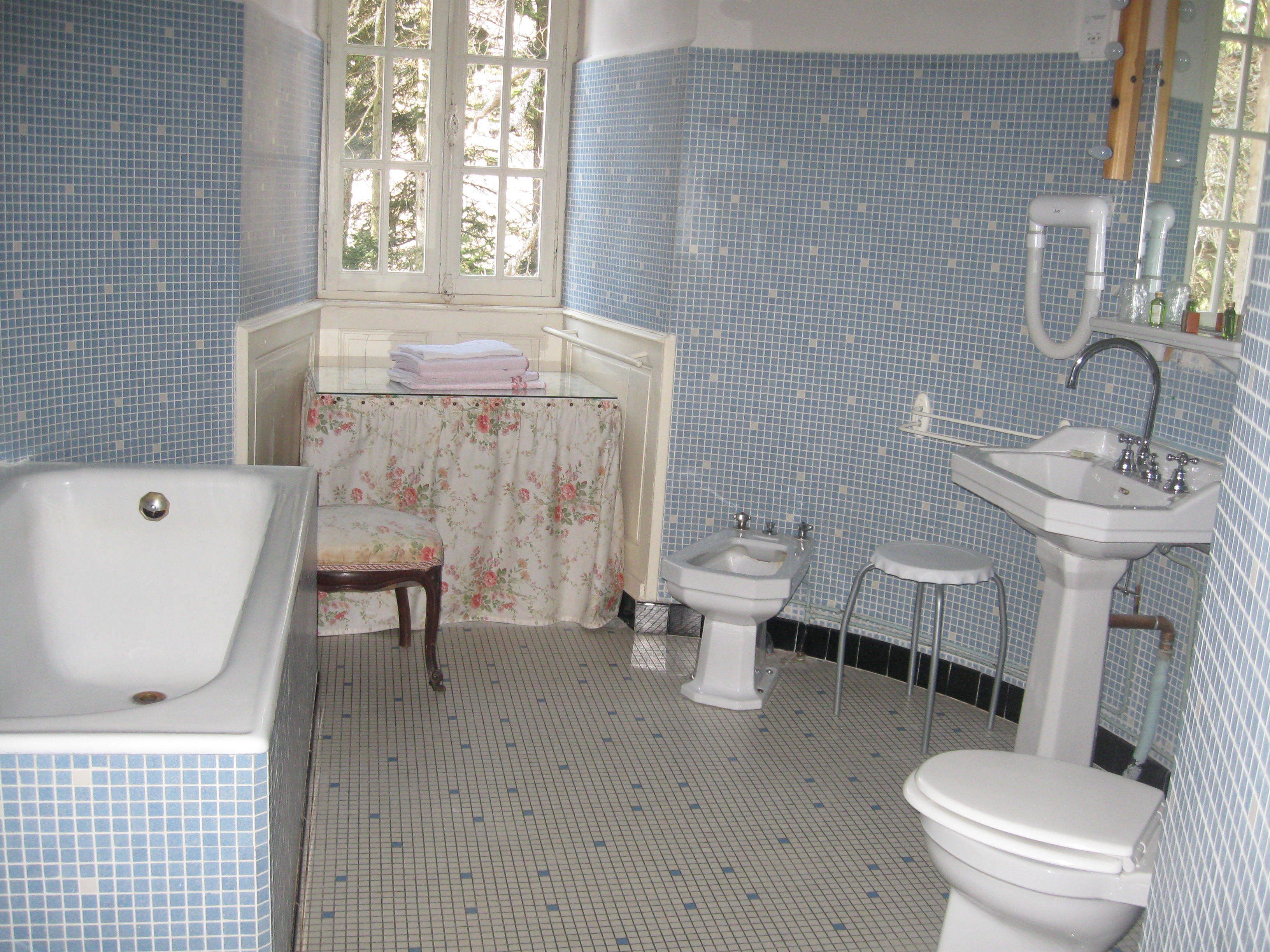 A bathroom with a bathtub, a sink, a toilet, and a window.