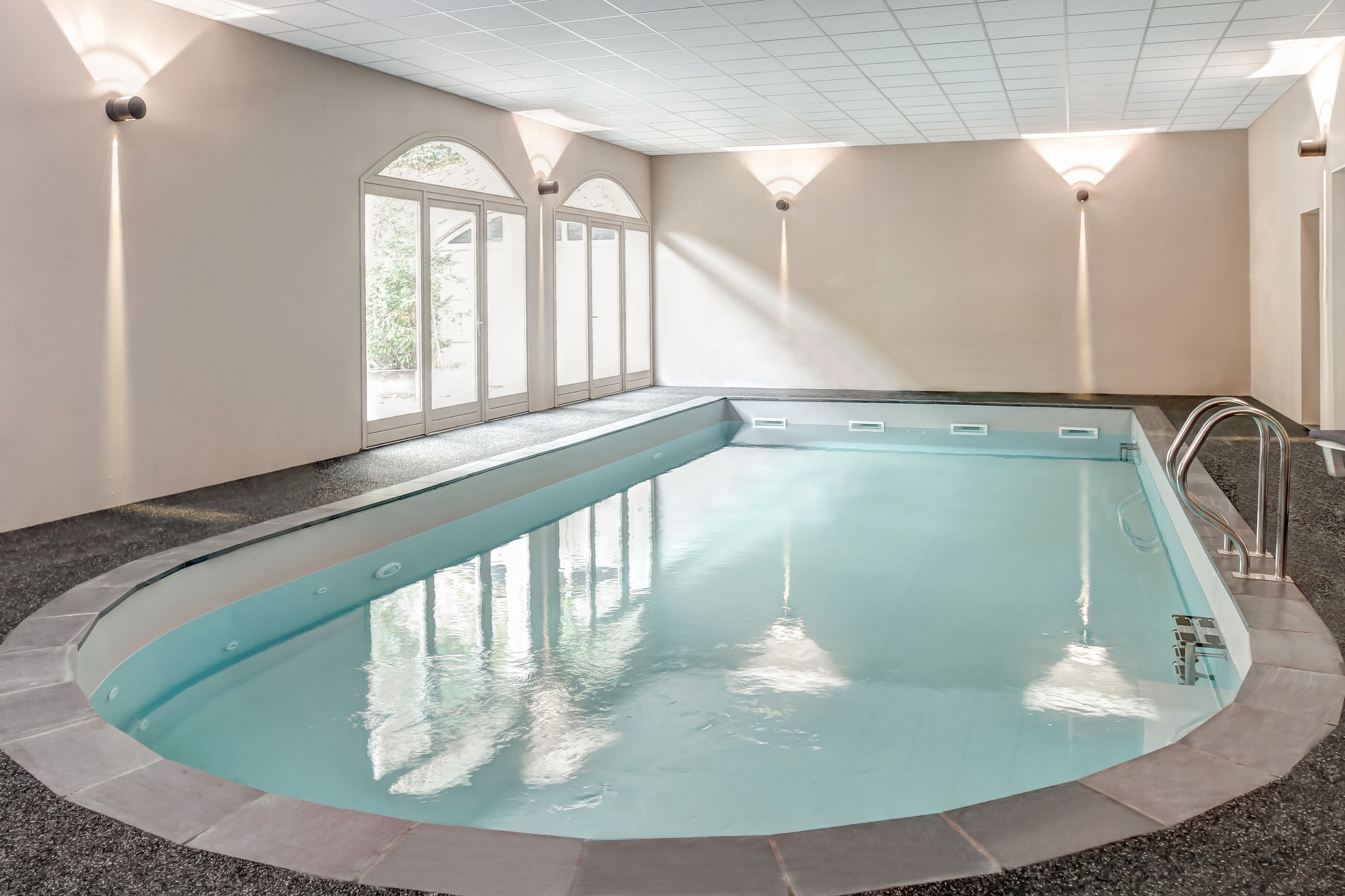 Alberca techada, alberca al aire libre y camastros