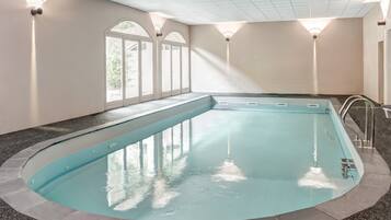 Een binnenzwembad, een buitenzwembad en ligstoelen