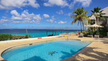 Una piscina al aire libre, sillones reclinables de piscina