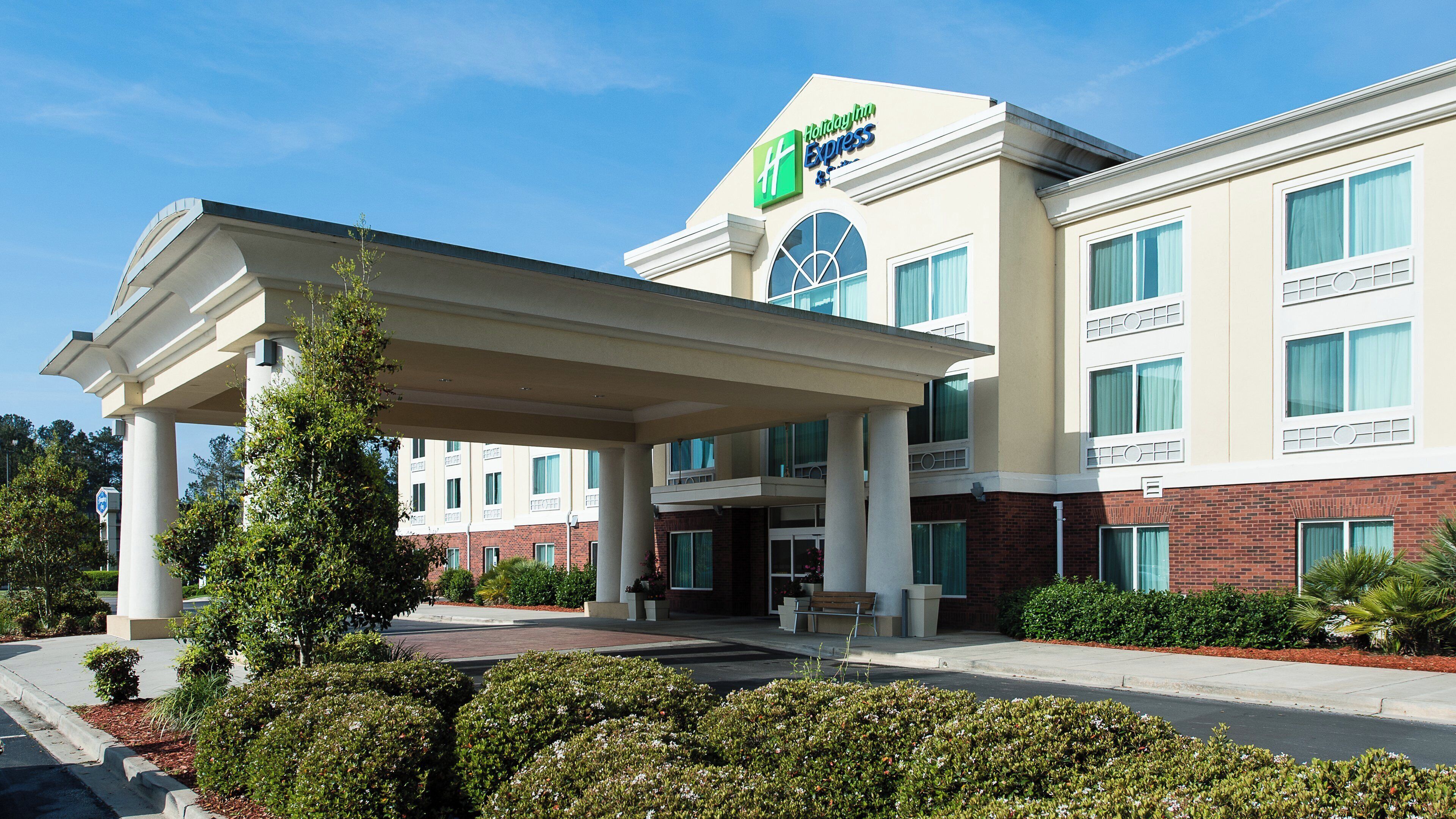Um hotel Holiday Inn Express com entrada coberta, diversas janelas e fachada de tijolos.