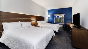 A hotel room with two beds, a desk, a television, and a window with a view of trees. - Holiday Inn Exp Walterboro by IHG (Walterboro)