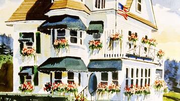 A large, multi-story house with a prominent tower, multiple windows, and a well-maintained garden with flowers.
