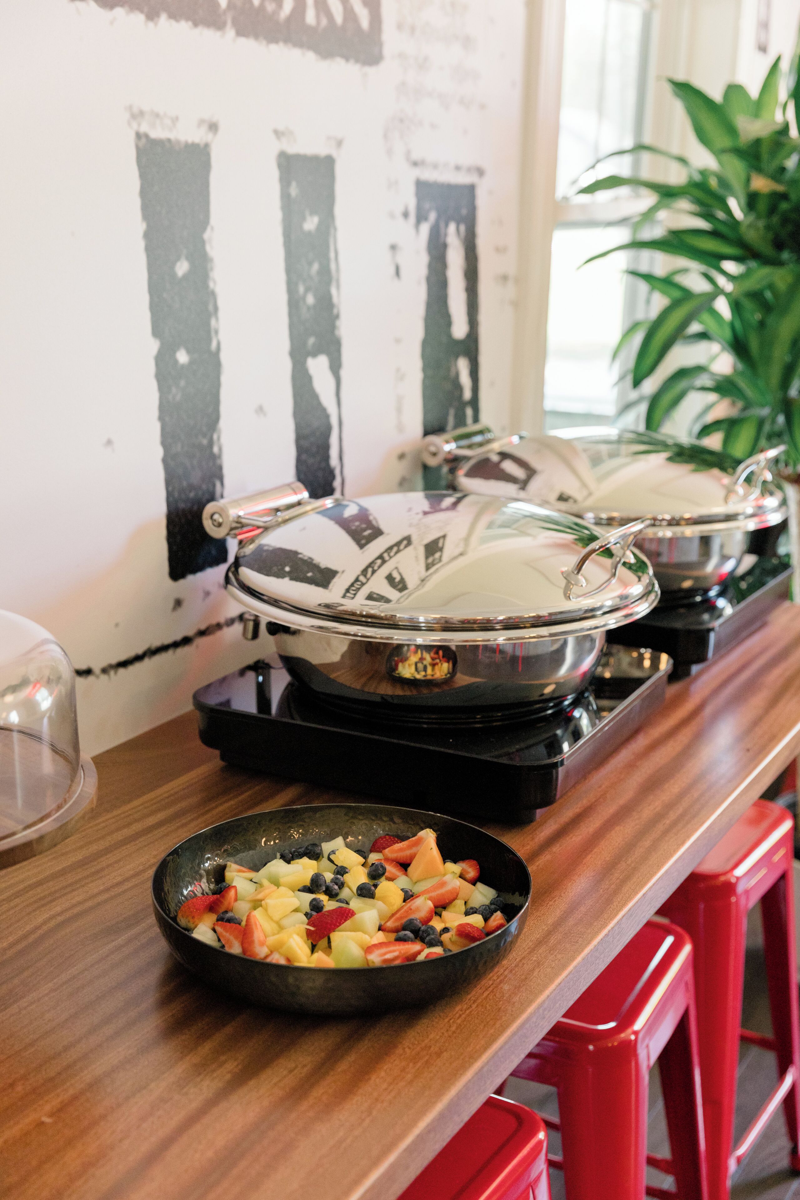 A kitchen counter with a fruit bowl and a stove with pots.