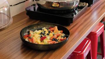 A kitchen counter with a fruit bowl and a stove with pots.