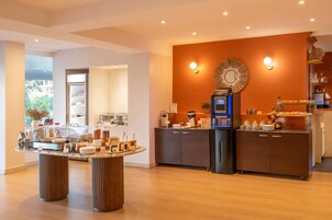 Una cocina moderna con cafetera, refrigerador y mostrador tipo buffet.