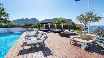 Een buitenzwembad en ligstoelen