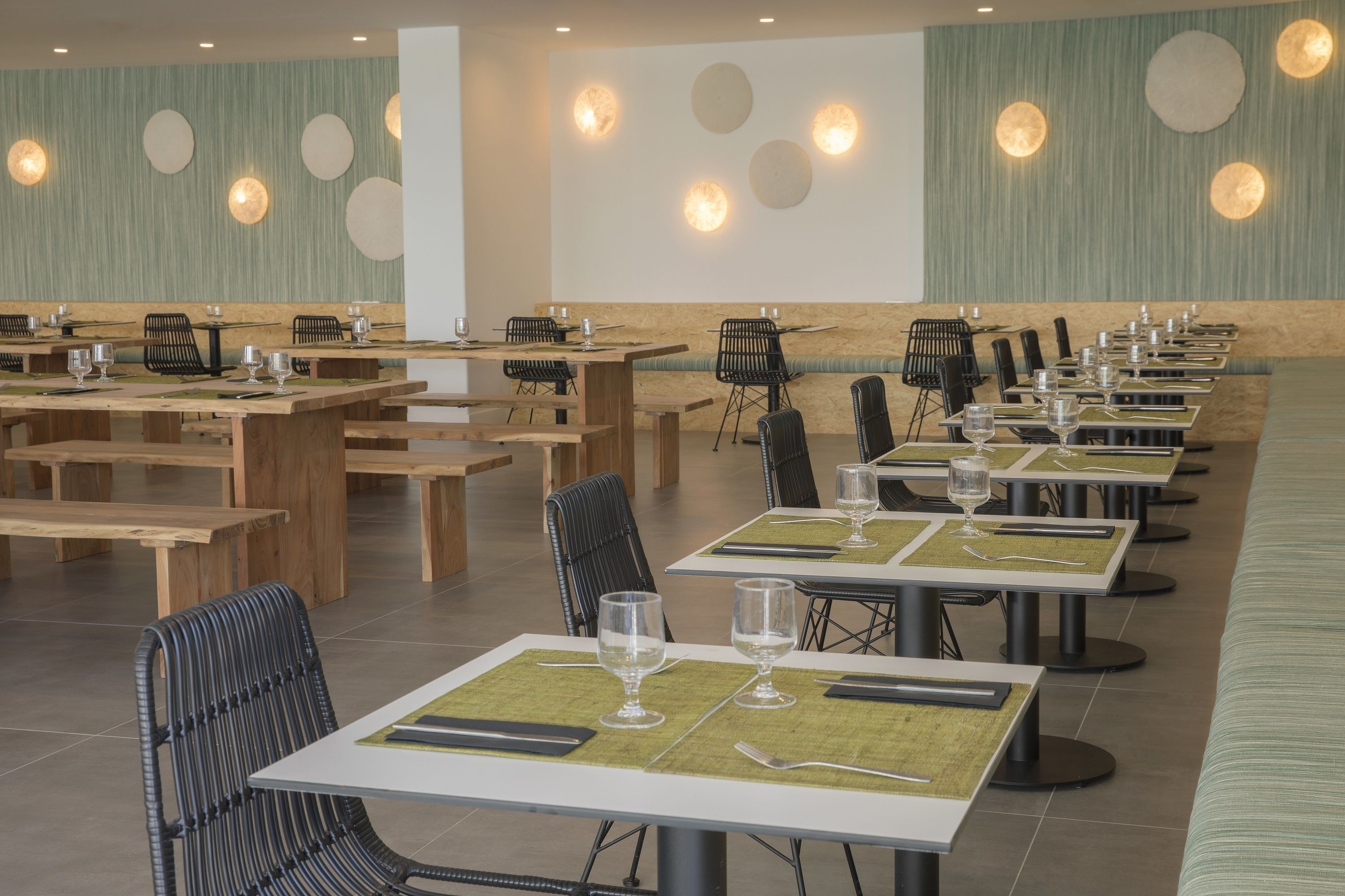 Un restaurante con varias mesas, sillas y bancos.